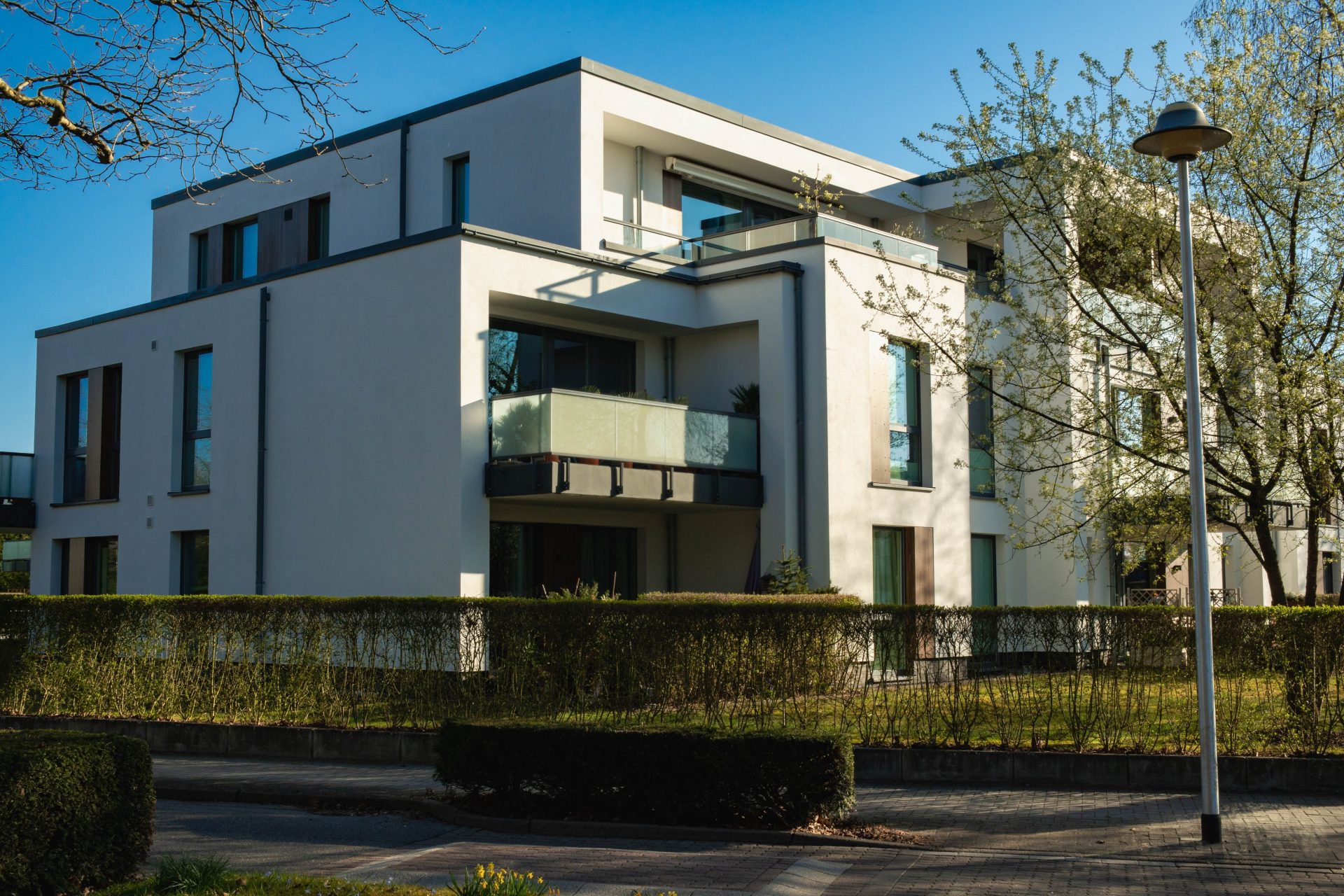 Contemporary luxury apartment building surrounded by spring greenery in a residential area.